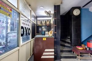 a restaurant with a staircase and a clock on the wall at Hotel Swarna Mayuri in Guntūr