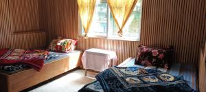 a small room with two beds and a window at Wang Homestay in Sukhia Pokhari