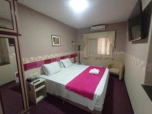 ein Schlafzimmer mit einem großen weißen Bett und einer rosa Decke in der Unterkunft Inter Park Hotel in Ponta Porã + 37 Fotos