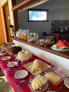 a table with cakes and other food on it at Pousada Mirante de Areia-Itaúnas in Itaúnas