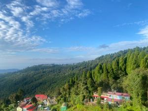 a view of a mountain with houses and trees at Wang Homestay in Sukhia Pokhari