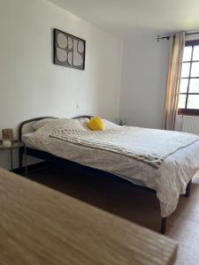 a bedroom with a bed with a yellow pillow on it at Le Pavillon in Vendôme