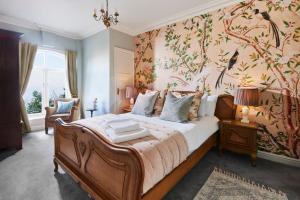 a bedroom with a large bed with a floral wallpaper at The Spa Chalet Scarborough Hot tub, pool, gym, beach location in Scarborough +49 photos