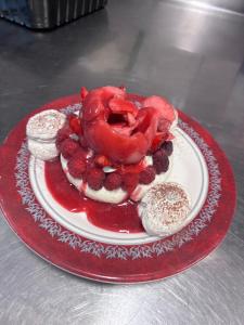 a plate of food with a donut and berries on it at Aux berges de Pareloup in Salles-Curan