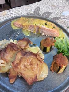 a plate of food with meat and vegetables on a table at Aux berges de Pareloup in Salles-Curan