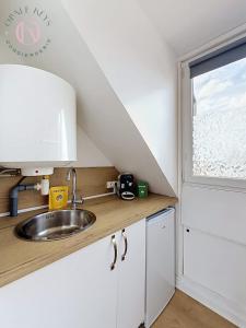 a kitchen with a sink and a window at Le Studio Bleu - Dernier etage & Confort in Coudekerque-Branche