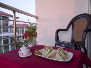 a table with a plate of sandwiches and a cup of coffee at Inani Royal Resort in Ināni