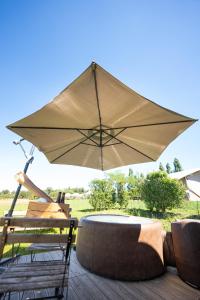 a patio with a table and an umbrella at Lodge des Bois Jacuzzi in Target