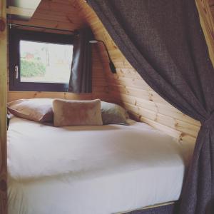 a bed in a log cabin with a window at Lodge des Bois Jacuzzi in Target