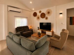 a living room with two couches and a flat screen tv at Sawan villa in Hinkong