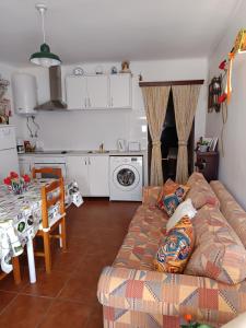 a living room with a couch and a kitchen at Casa Benlindha in Degolados