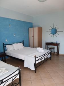 a bedroom with two beds and a sun sign on the wall at Studio nikolos in Elafonisos