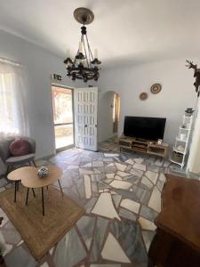 a living room with a chandelier and a television at Rokombo House Tinos in Tinos