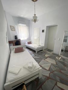 a room with two beds and a mirror at Rokombo House Tinos in Tinos
