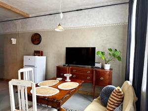 ein Wohnzimmer mit einem Tisch und einem Fernseher in der Unterkunft K's Studio in Kuldīga