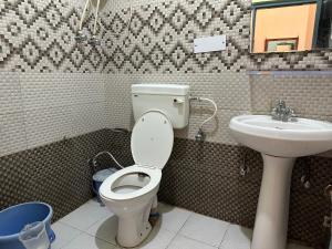 a bathroom with a toilet and a sink at Backpacker Inn Mcleod in Dharmsāla