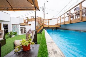 a pool in the middle of a building with green grass at El Templo Surf House in Punta Hermosa