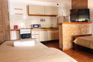 a small kitchen with a bed and a microwave at Cabañas Nazareth in Villa Carlos Paz +2 photos