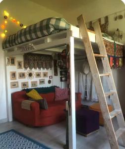 a loft bed with a couch in a room at Latte e Menta House in Casale