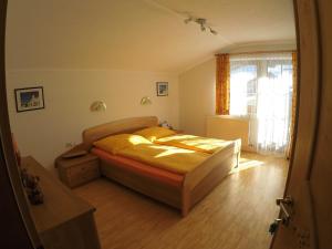 sypialnia z łóżkiem z żółtą pościelą i oknem w obiekcie Ferienwohnung GIA w mieście Haus im Ennstal