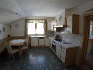 kuchnia ze stołem, zlewem, stołem i krzesłami w obiekcie Ferienwohnung GIA w mieście Haus im Ennstal