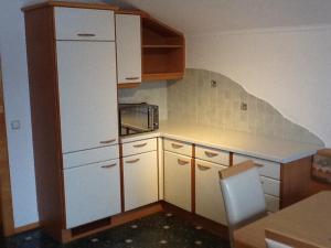 W kuchni znajduje się biała lodówka i kuchenka mikrofalowa. w obiekcie Ferienwohnung GIA w mieście Haus im Ennstal