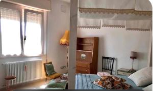 a bedroom with a bed and a chair and a window at Latte e Menta House in Casale