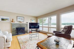 ein Wohnzimmer mit Kamin und Fernseher in der Unterkunft Loon Watch in Alton Bay