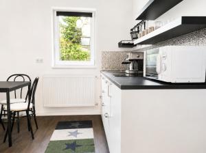 a kitchen with white cabinets and a black counter top at Garden Home in Törökbálint
