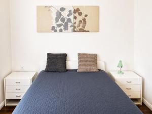 a bedroom with a blue bed with two night stands at Garden Home in Törökbálint