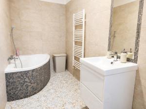 a bathroom with a tub and a sink at Garden Home in Törökbálint