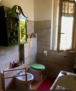 a bathroom with a green toilet and a sink at Latte e Menta House in Casale +9 photos