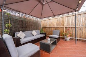 an outdoor patio with a couch and a table at El Templo Surf House in Punta Hermosa