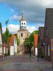an old building with a clock tower on a street at Schlosspartie stilvolle Ferienwohnung an der Nordsee in Sande