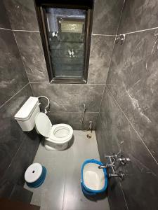 a small bathroom with a toilet and a sink at Hotel Sumeet Palace in Shirdi