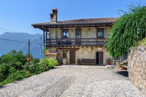 a stone house with a balcony and a patio at Agriturismo El Giardì in Marone +87 photos