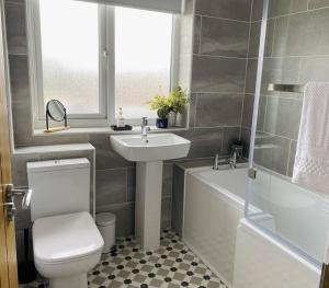 a bathroom with a sink and a toilet and a bath tub at Foxcroft in Brighouse +28 photos