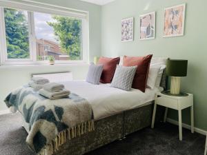 a bedroom with a bed with pillows and a window at Foxcroft in Brighouse