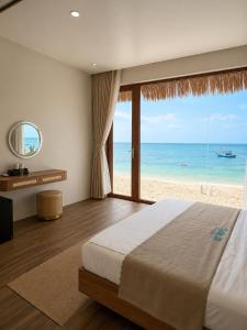 a bedroom with a bed and a view of the beach at Sala Beach Villa Phú Quý in Cù Lao Thu