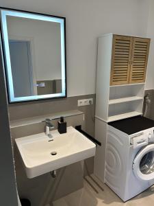 a bathroom with a sink and a washing machine at Moderne Studio Oase in Donaueschingen