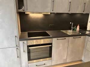 a kitchen with a stove top oven and a sink at Moderne Studio Oase in Donaueschingen
