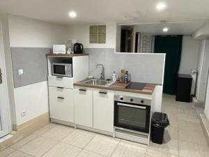 a small kitchen with a sink and a microwave at Grande chambre, Sdb partagée in Angers