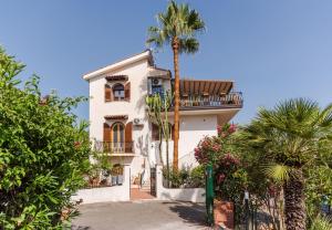 a white house with a palm tree in front of it at Villa Domina by Letstay in Giardini Naxos