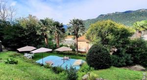 a swimming pool in a yard with umbrellas at Villa Marina Como Boutique B&B & Apartments in Como