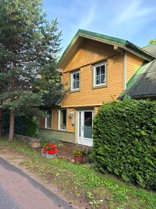 a yellow house with flowers in front of it at Saules nams in Rucava