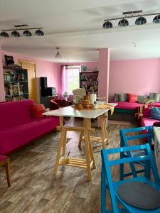 a living room with a table and pink walls at Saules nams in Rucava