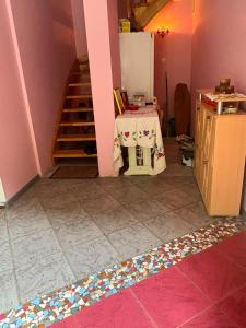 a kitchen with a table and a staircase in a room at Saules nams in Rucava