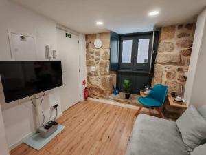 a living room with a couch and a tv at Apartamento com charme no centro histórico - Escura 36 in Viseu