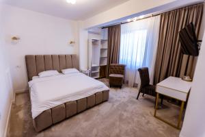 a hotel room with a bed and a desk and a desk at Jolie Boutique Hotel Corp B in Craiova