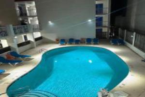 a large swimming pool with blue chairs in a room at Hotel Ocean27 Oceanfront in Virginia Beach